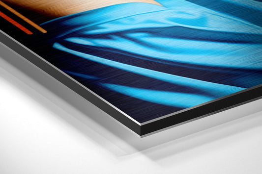 Close-up angled view of brushed aluminum Dibond panel edge showing layered material construction with blue neon artwork visible on surface.