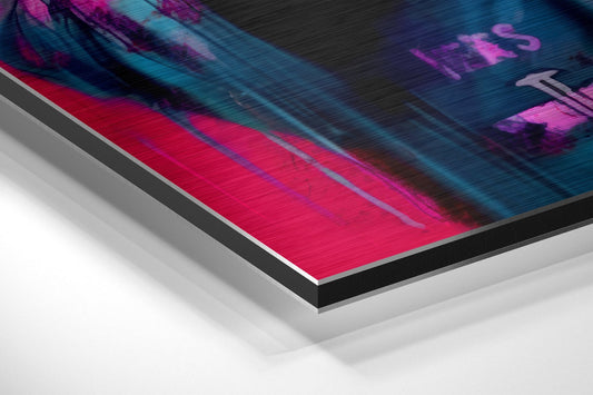 Angled close-up view of brushed aluminum dibond wall art showing vibrant pink, magenta, and teal colors with blurred textural elements and layered metal edges.