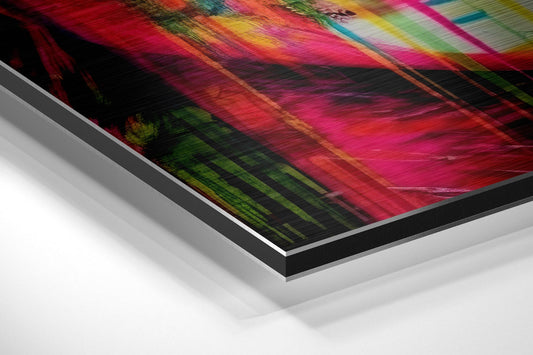 Angled perspective view of brushed aluminum dibond wall art displaying vibrant rainbow streaks and blurred motion effects on black background.