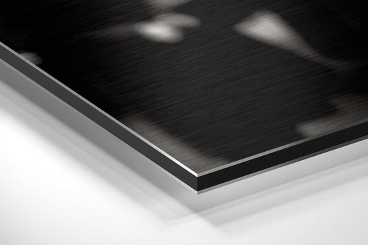 Close-up angled view of layered brushed aluminum and black Dibond wall art showing edge detail and material texture.