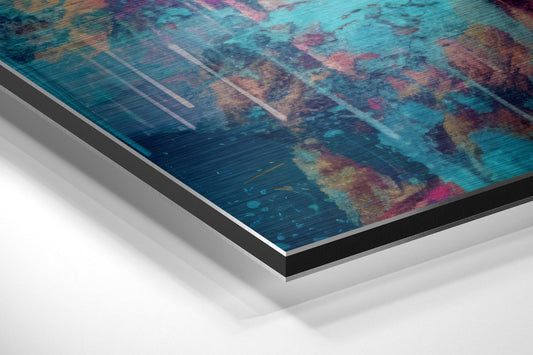 Angled close-up view of layered aluminum dibond wall art showing vibrant teal, magenta, and brown brushstrokes with metallic edges.