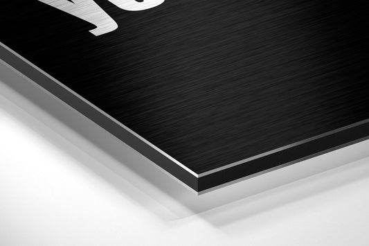 Close-up angled view of layered black brushed aluminum and white composite materials showing edge detail and depth of the dibond wall art panel.