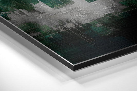 Close-up angled view of layered aluminum dibond print showing emerald and gray tones with architectural grid patterns, displaying material thickness and edges.