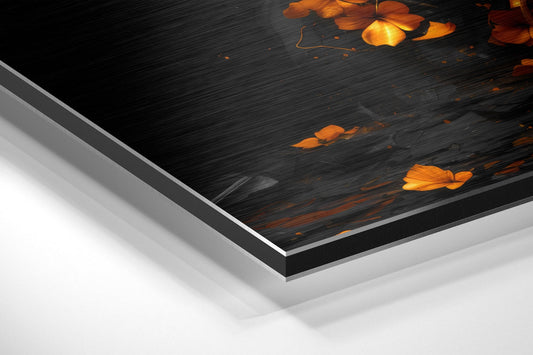 Close-up angled view of layered aluminum dibond print showing dark brushed surface with golden butterfly and ember details.
