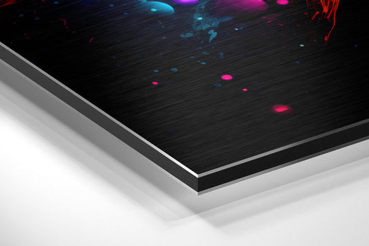Angled perspective view of brushed aluminum Dibond panel with black surface featuring cyan, magenta, and red luminous particles and streaks against white layered backing.