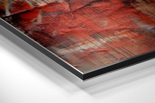 Close-up angled view of layered aluminum dibond print showing crimson textured boxing scene with black border and white backing visible.