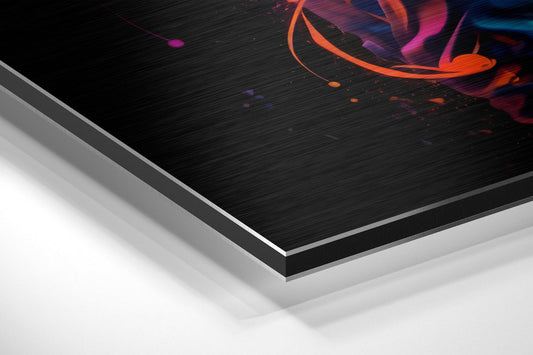 Angled close-up view of layered brushed aluminum dibond showing black surface with vibrant orange and pink abstract bursts against white backing layers.