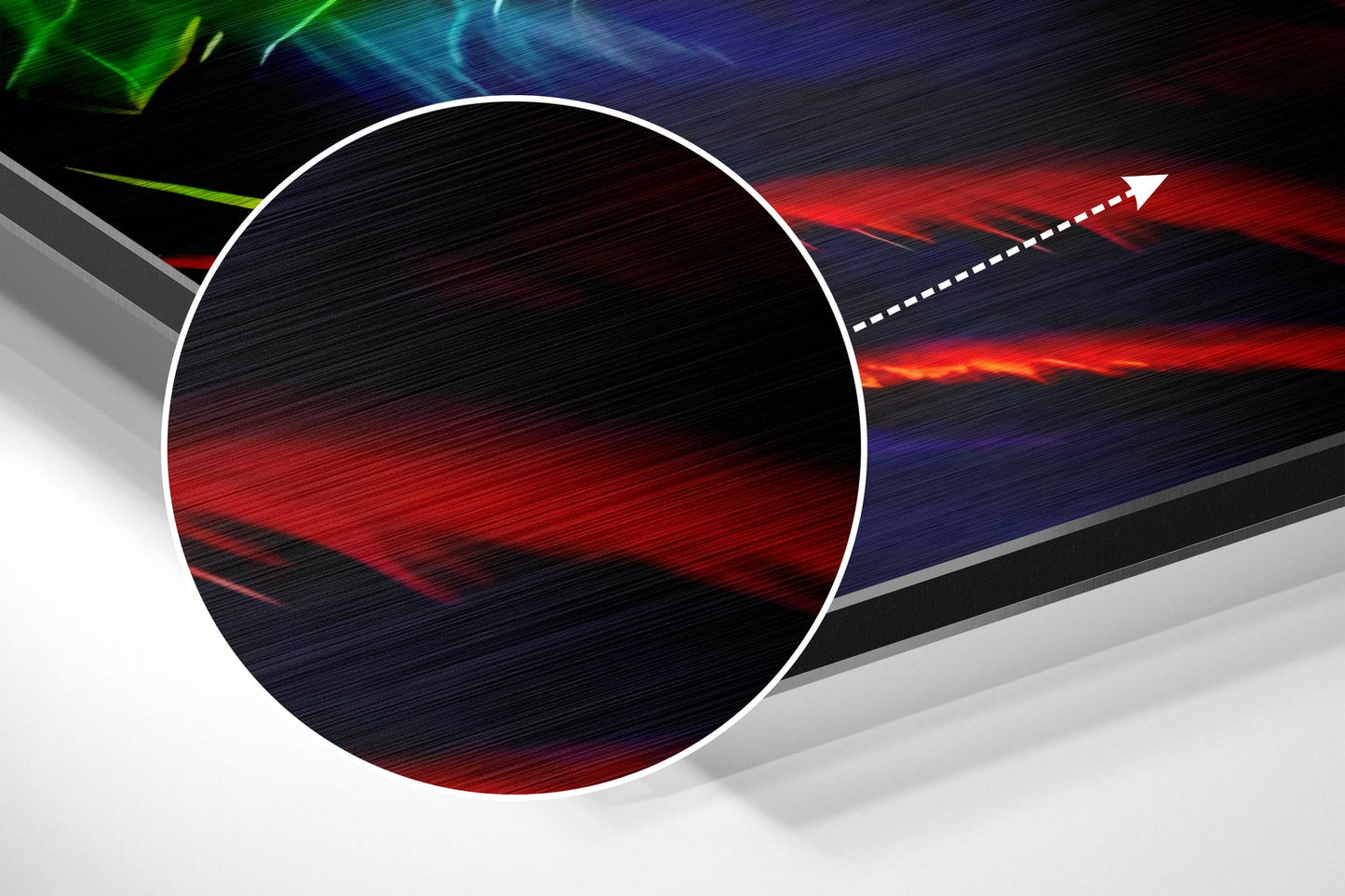 Close-up angled view of circular brushed aluminum art with red and dark blue streaked pattern and white border against colorful background.