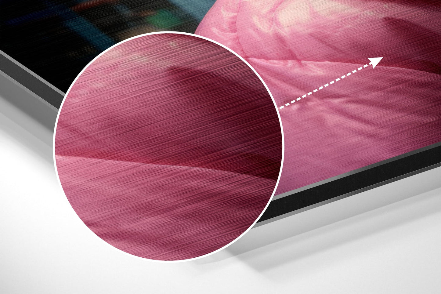 Close-up angled view of pink brushed aluminum circular wall art with white border and directional arrow detail.