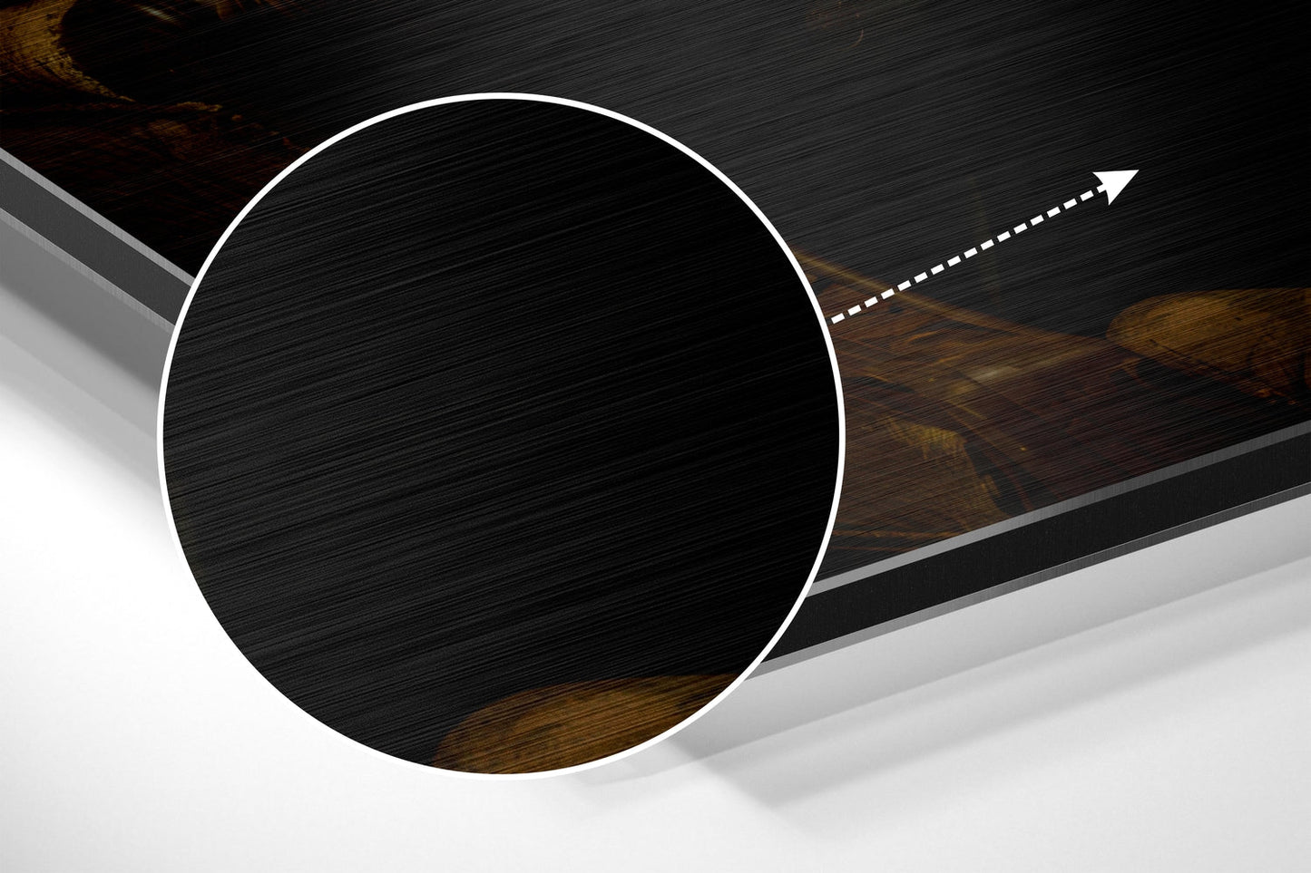 Close-up angled view of brushed aluminum circular wall art with white border and textured black surface showing wood grain detail.
