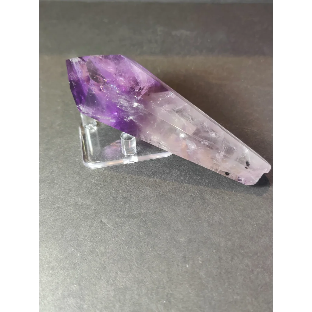 Amethyst polished scepter wand with translucent purple crystal gradient from deep violet to pale lavender on metal stand
