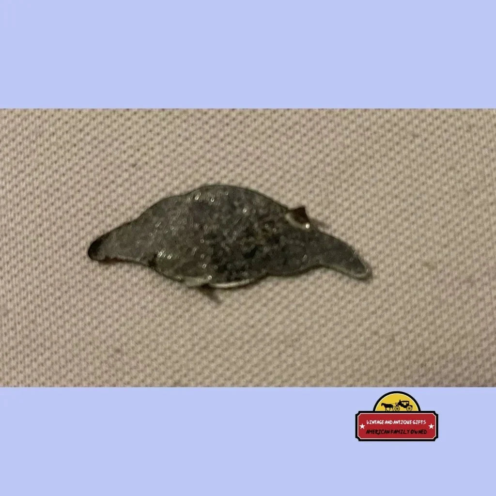 Dark-colored tin tobacco tag resembling a leaf or small animal from the 1870s