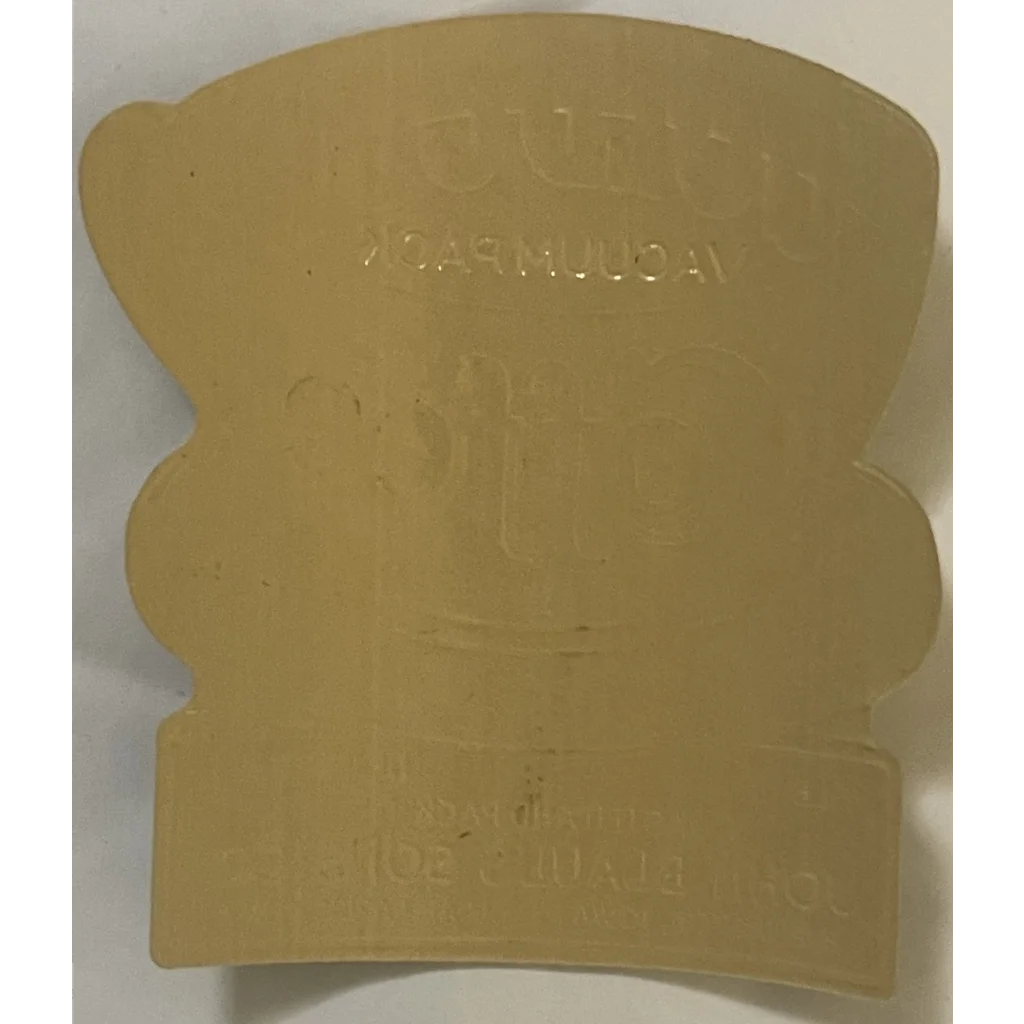 Beige plastic bread-shaped cookie cutter with embossed text next to Antique 1910s Gold Cup