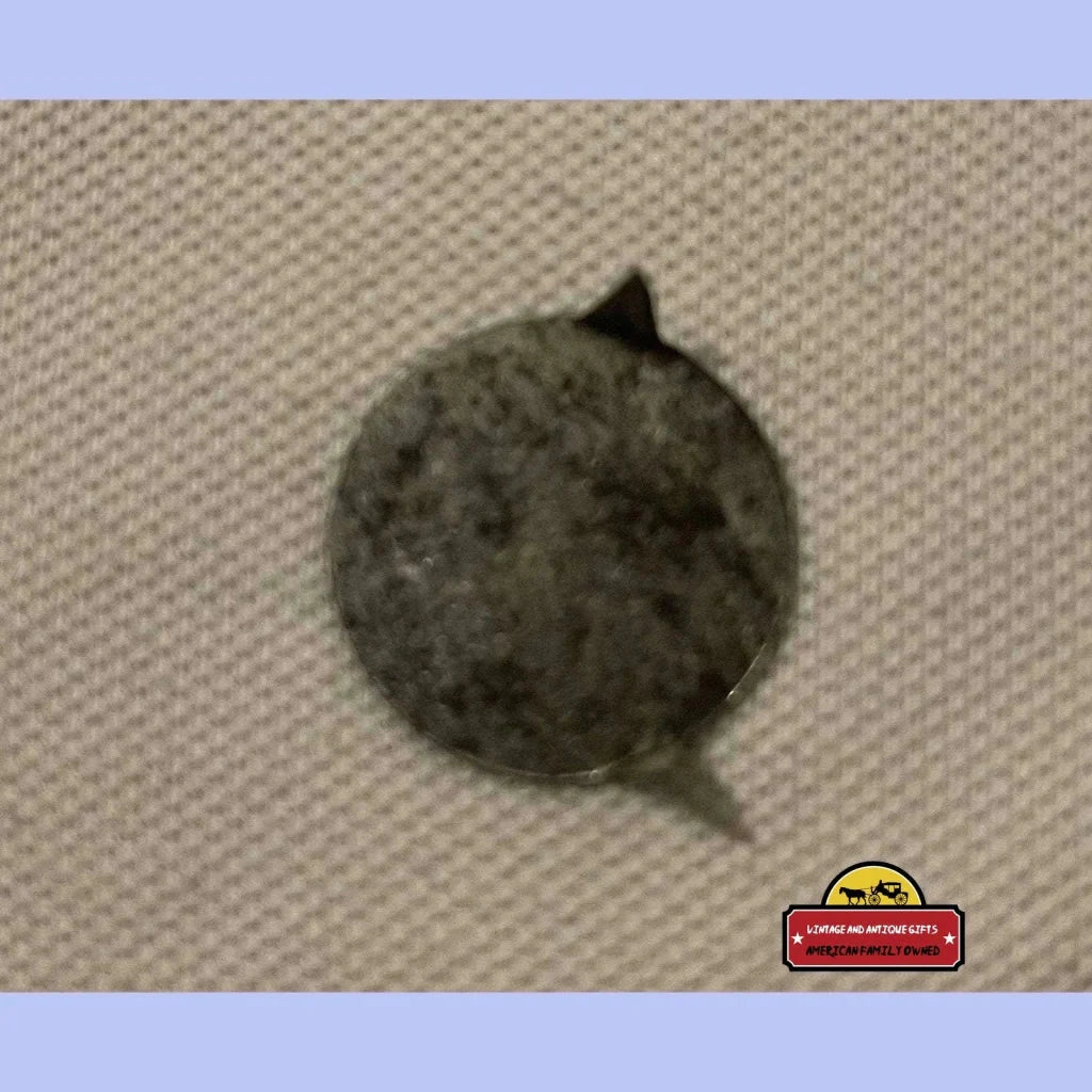 Fuzzy gray tin tobacco tag with a cat ear-like protrusion from the 19th century