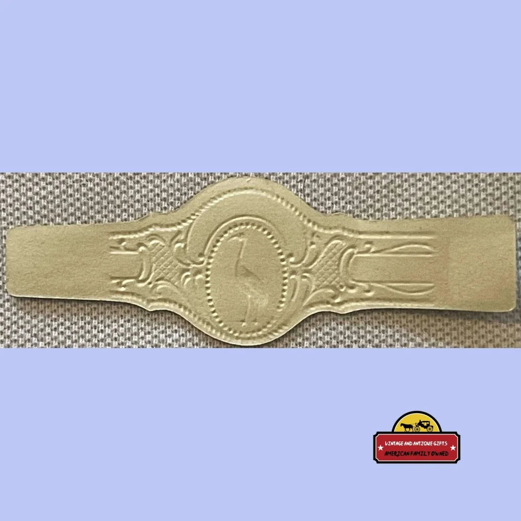 Gold-colored antique vintage cigar band with embossed giraffe design from the 1900s