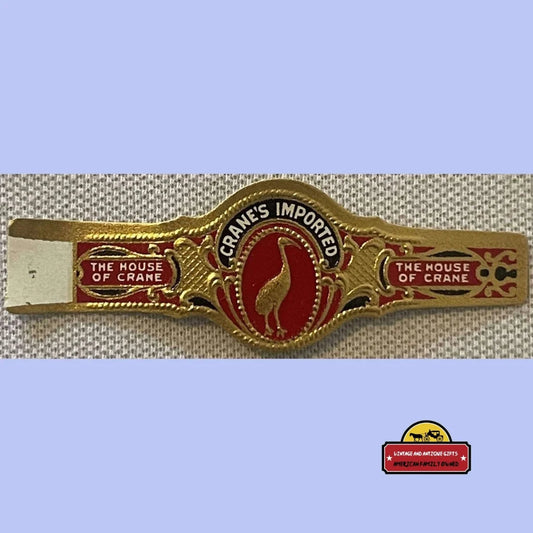 Vintage red and gold cigar band reading "Crane's Imported" and "The House of Crane" with crane bird.