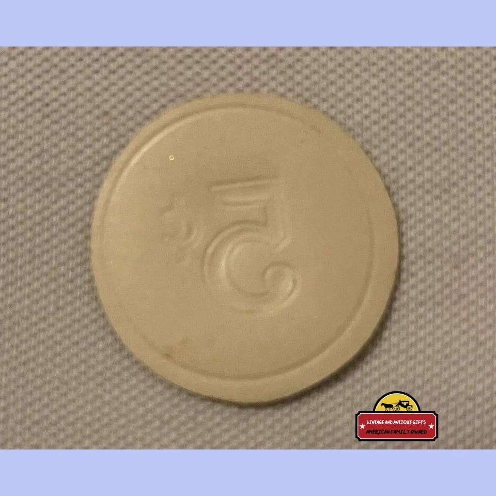 Circular beige plastic token featuring an embossed design from an antique vintage cigar label