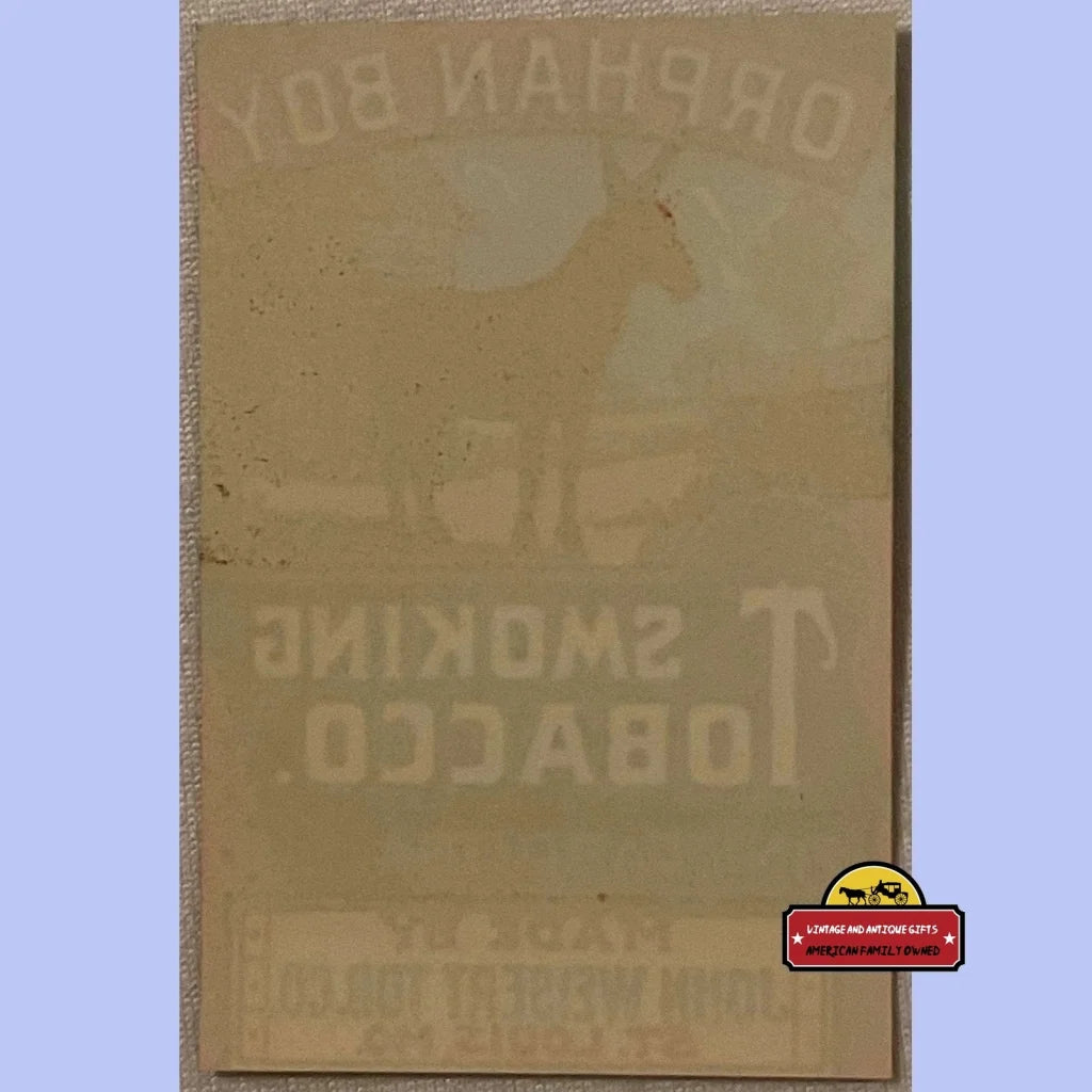 Reversed text on a vintage surface featuring the Rare Antique Orphan Boy Smoking label