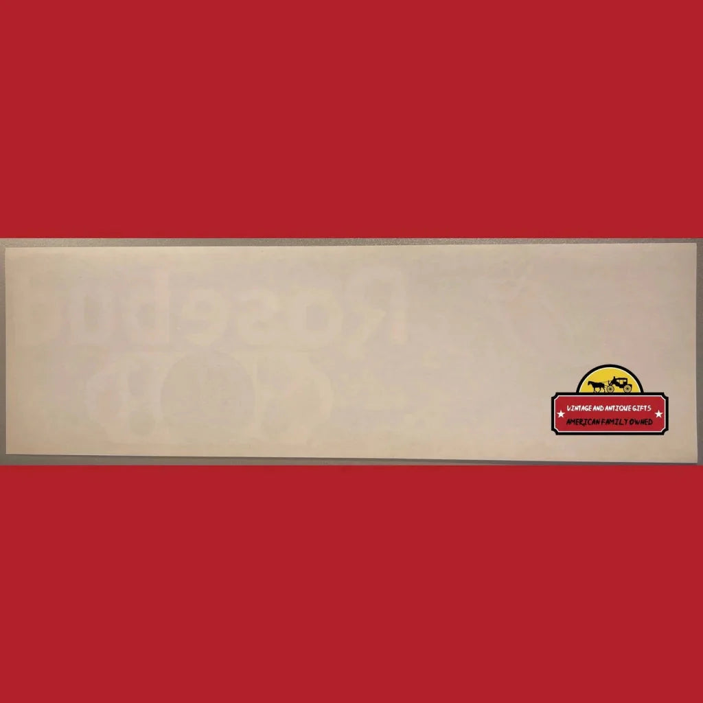 Beige wooden board showcasing a Rare 1950s Rosebud Crate Label with a colorful sticker