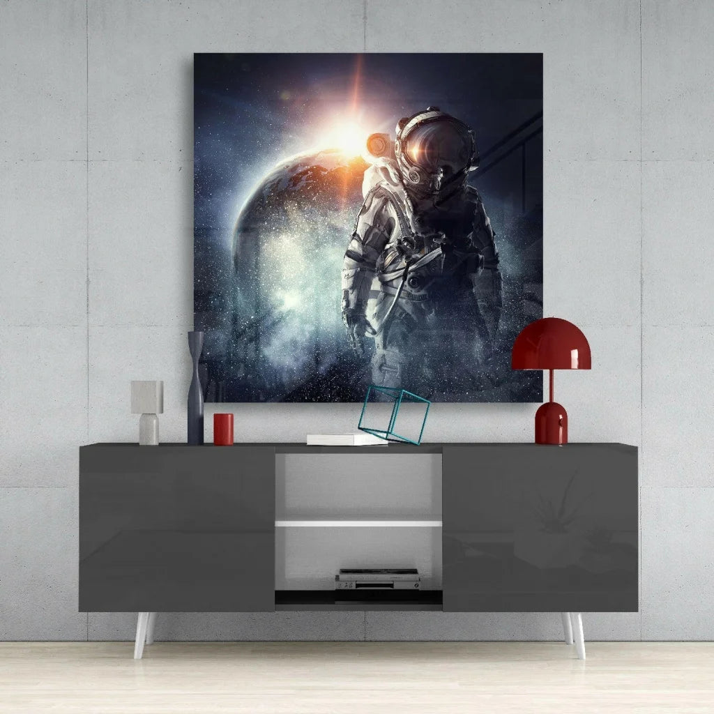 Astronaut in metallic suit before glowing planet on glass wall art