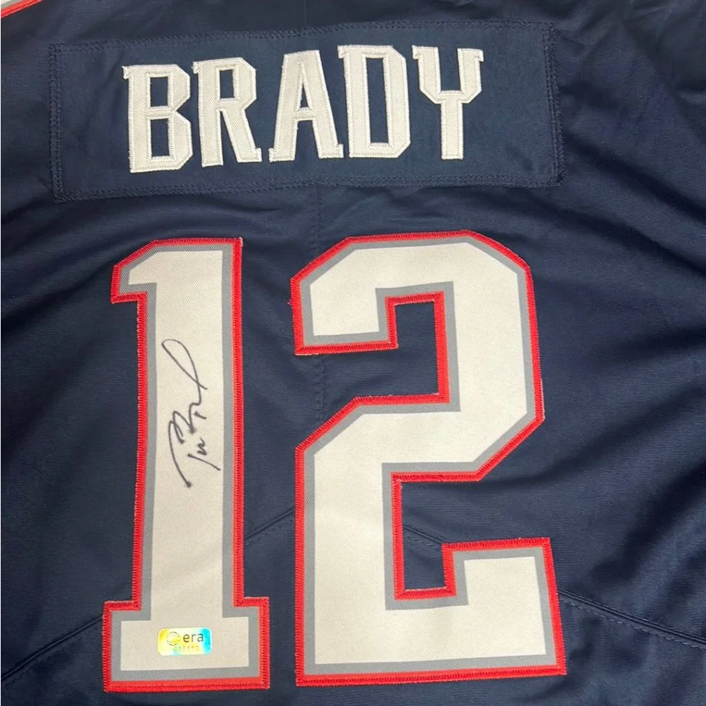 Navy blue official Tom Brady autographed Patriots jersey with white numbers and signature