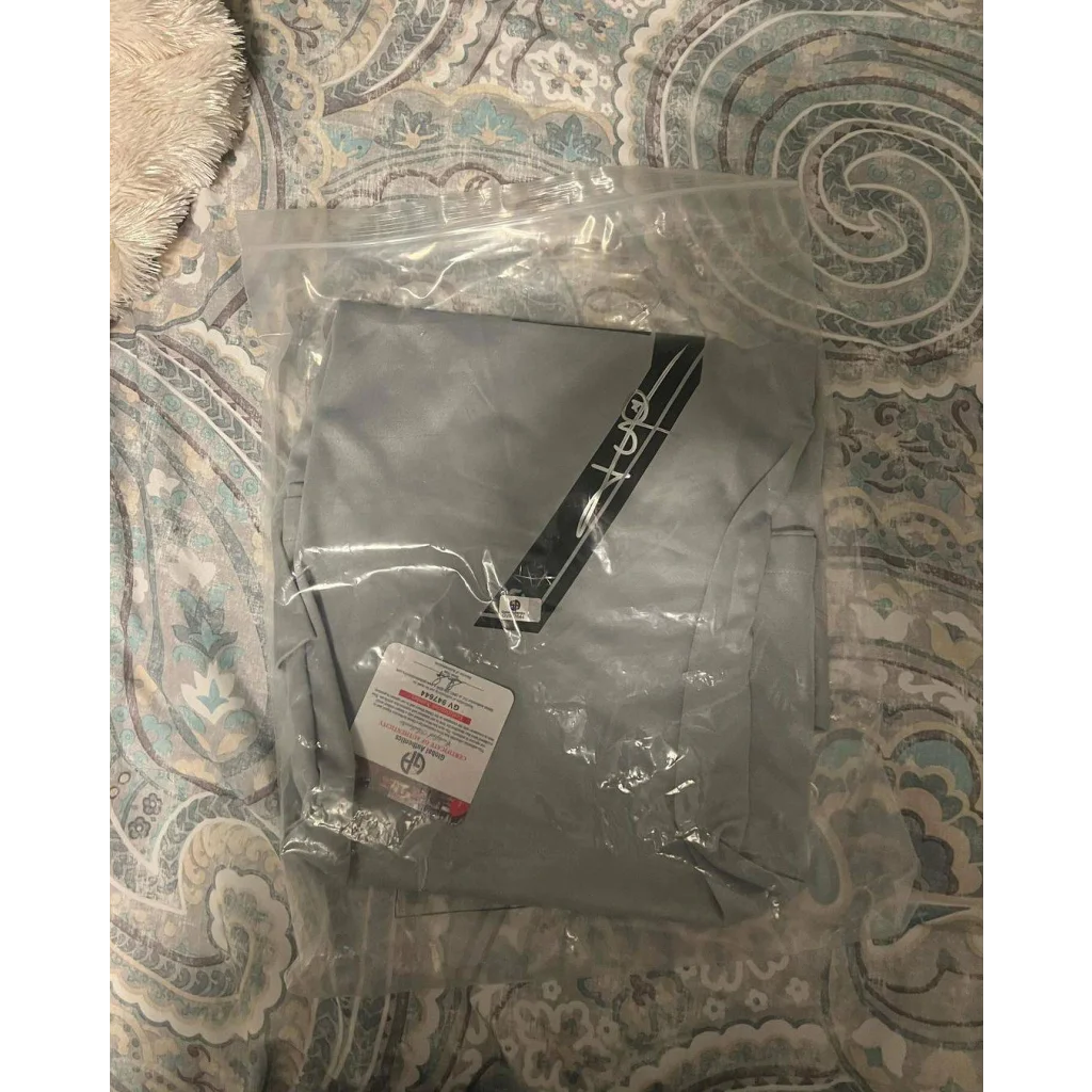 Light gray autographed Kylian Mbappe PSG jersey in clear plastic package with price tag