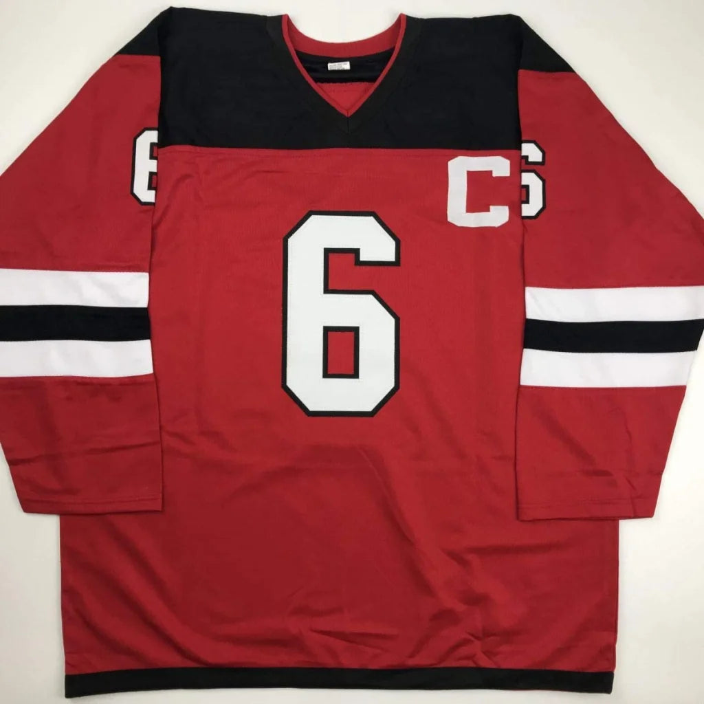 Red hockey jersey with black shoulders and white stripes for professional sports league fans