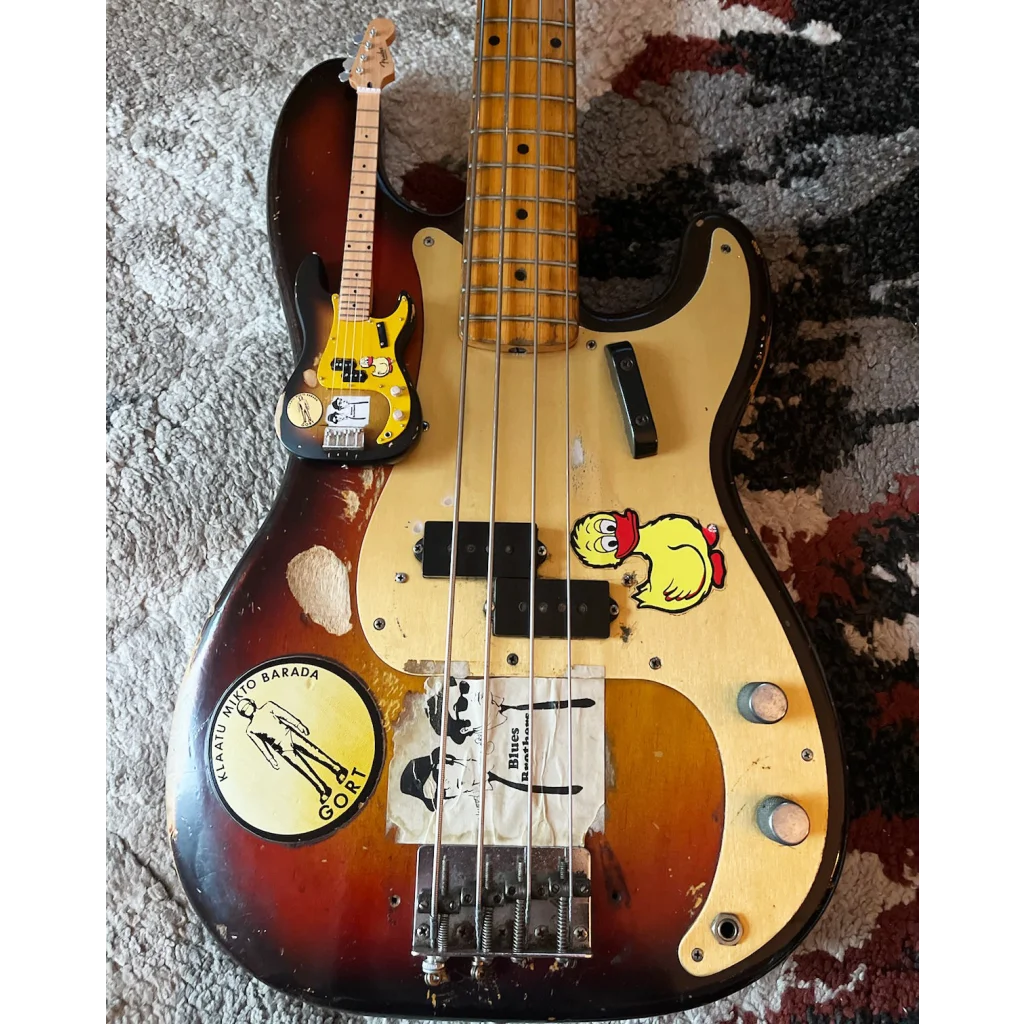 Mini 3-color sunburst Axe Heaven Fender Precision Bass with yellow pickguard, stickers, and adjustable A-frame stand