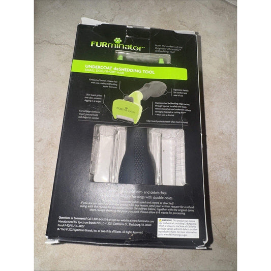 FURminator undercoat deshedding tool packaging displayed flat on concrete floor, showing black box with lime green accents and product features.