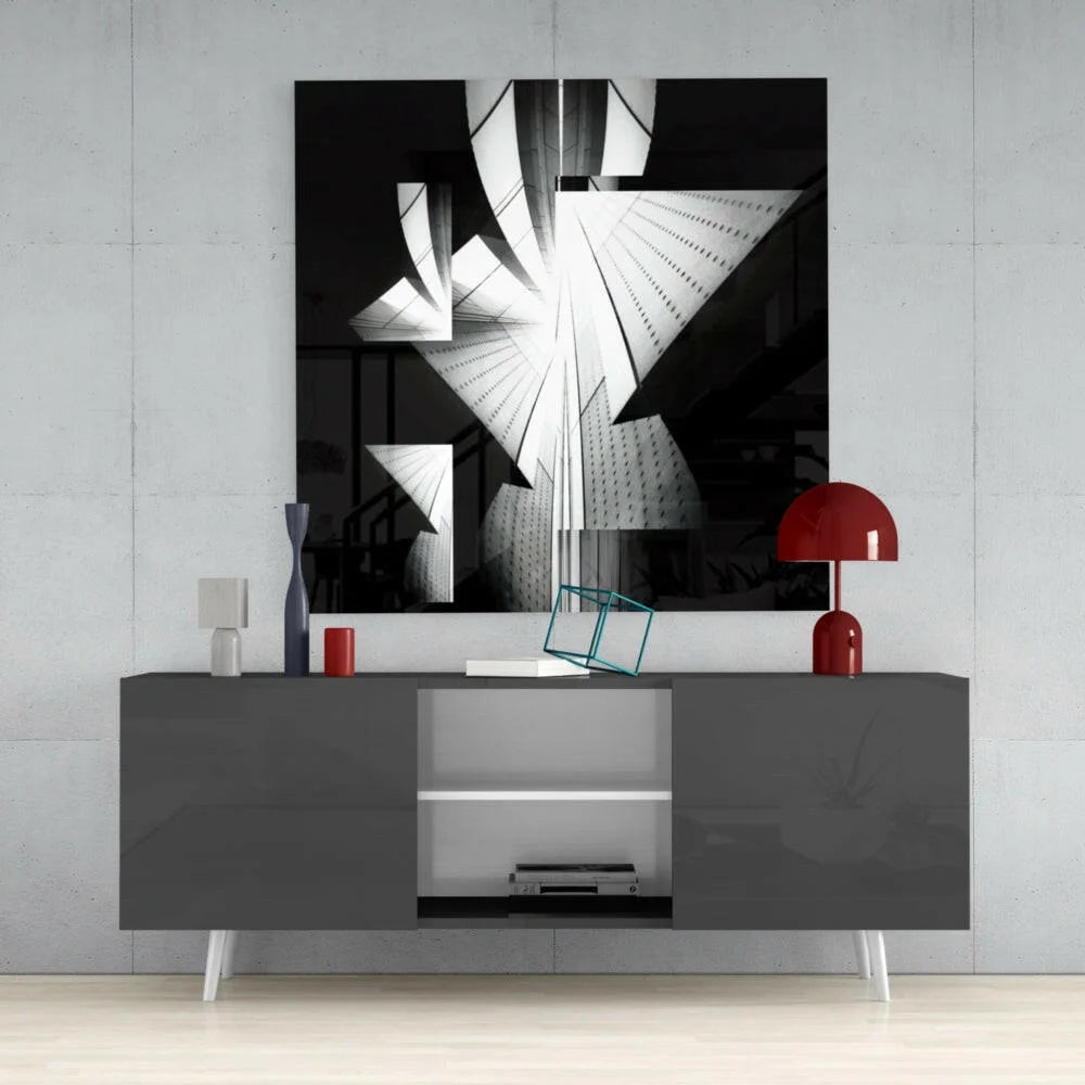 Modern gray lacquered sideboard with white legs and open storage, near bold geometric glass wall art