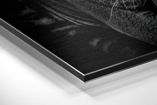 Close-up angled view of layered Dibond wall art showing brushed black aluminum surface with white backing layers.