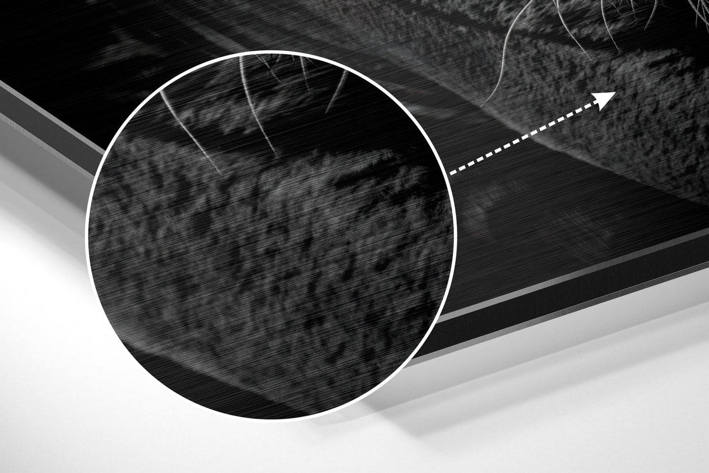 Close-up detail of brushed aluminium surface with circular white outline and directional arrow on black and gray abstract background.