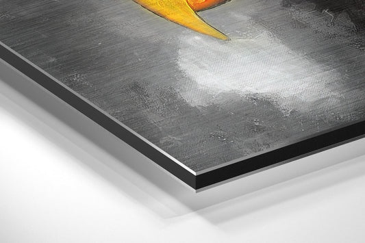 Close-up angled view of aluminum Dibond print showing layered edge construction with gray brushed surface and yellow beak detail visible at top.
