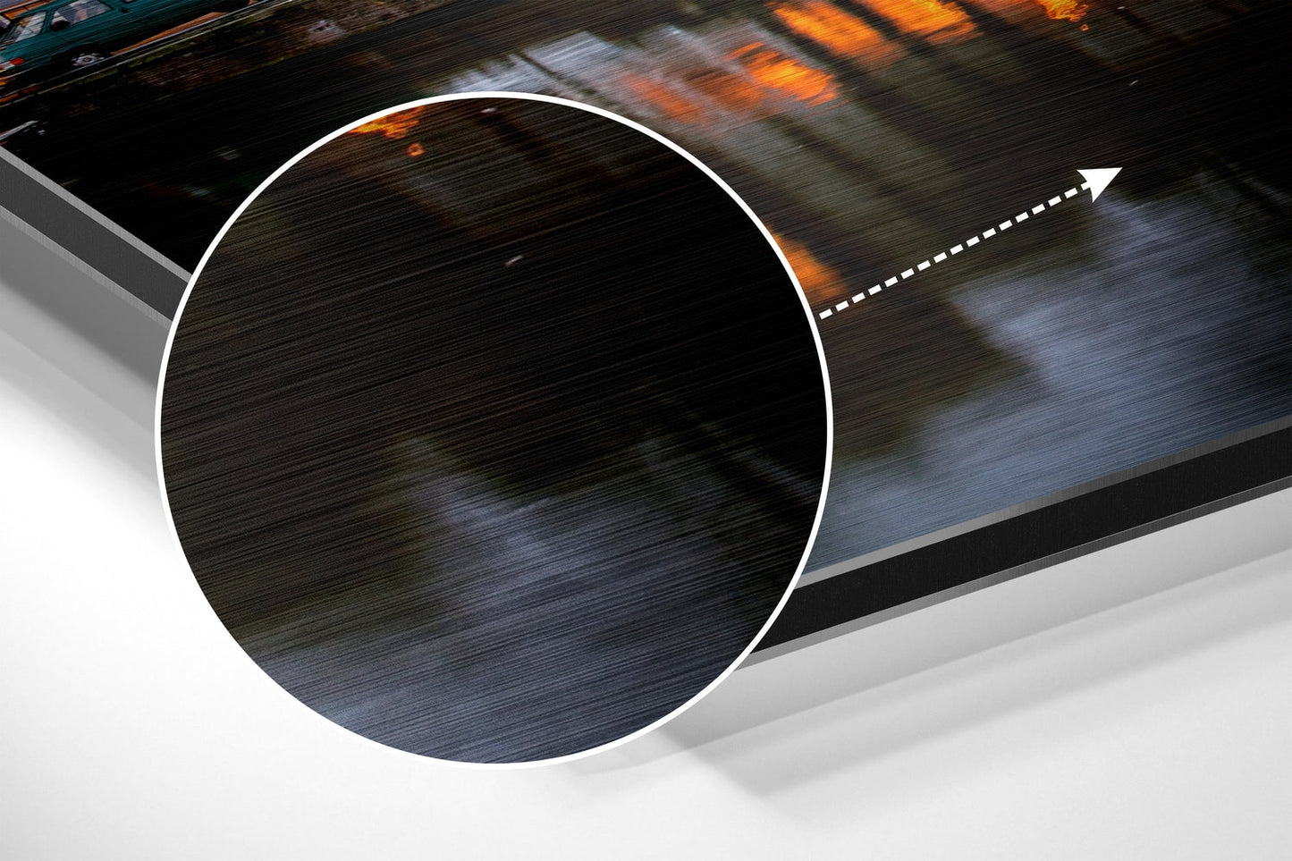 Close-up detail of brushed aluminum surface with circular white border and directional arrow, showing wood grain texture and blue-gray tones.