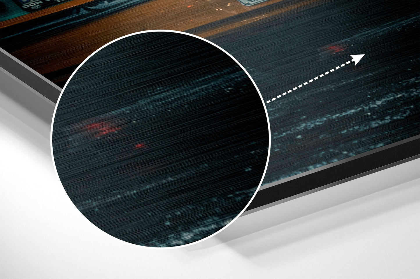 Close-up detail of brushed aluminum surface with horizontal streaks, teal and dark tones, white circular frame, directional arrow overlay.