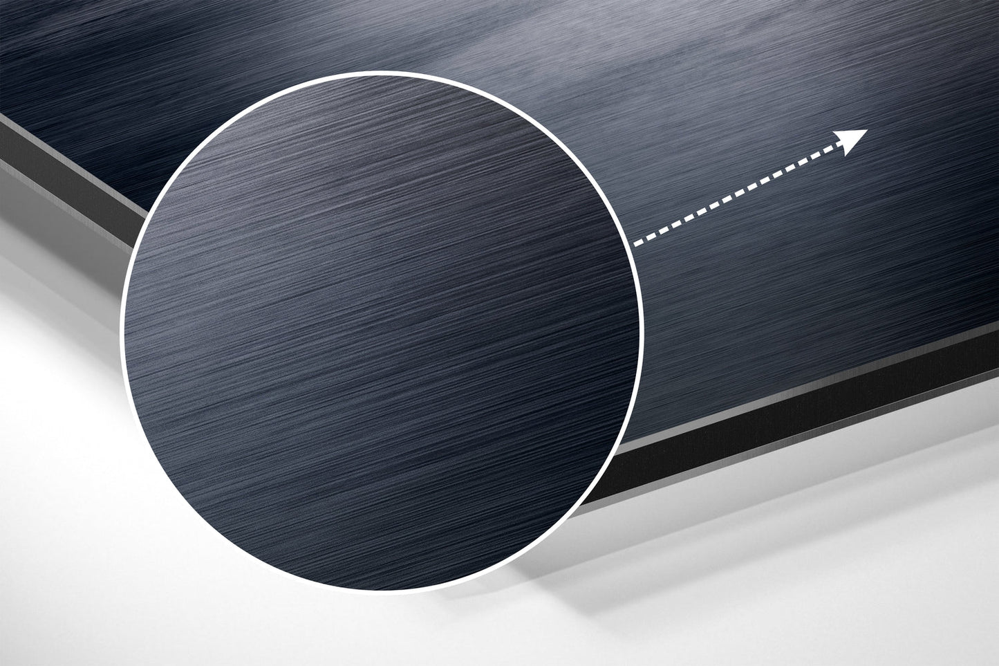 Angled close-up of brushed aluminum circular wall art with white border and directional arrow against layered gray background.