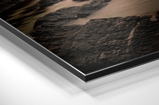 Close-up angled view of layered Dibond panel showing dark textured landscape print with white and gray aluminum backing layers.