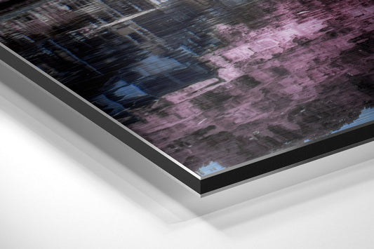 Angled close-up of framed wall art showing pink blossoms and blue water reflections on brushed aluminium with black border.