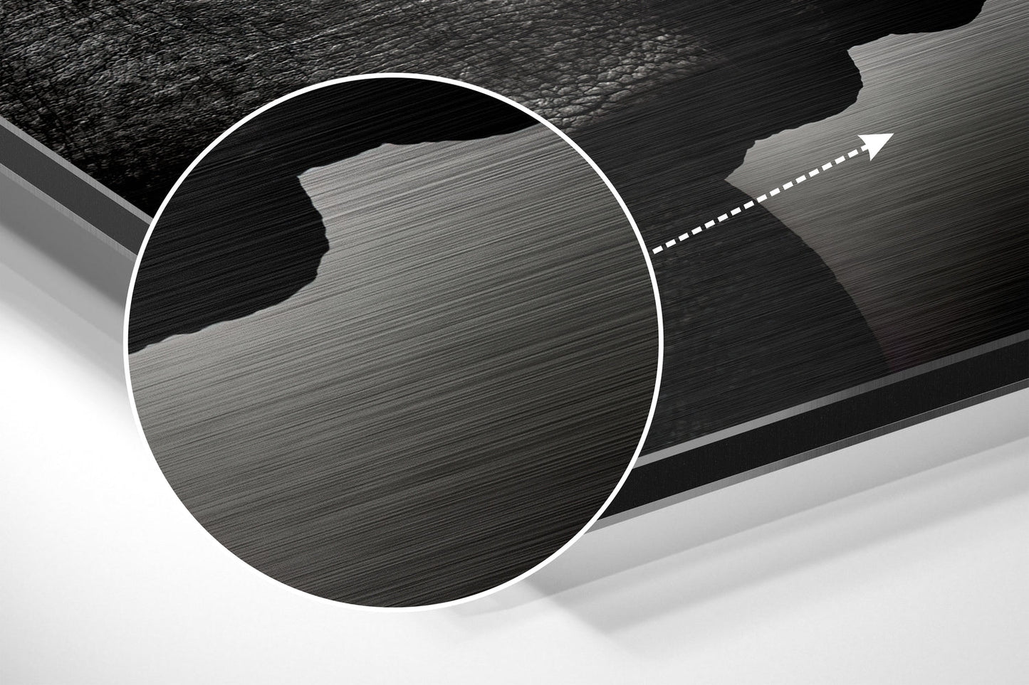 Close-up of brushed aluminium Dibond wall art showing textured metallic surface with circular white border and directional arrow detail.