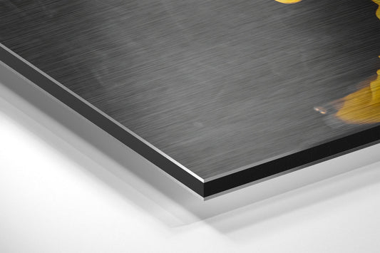 Close-up angled view of brushed aluminum dibond panel edge showing layered construction with black and white core layers beneath dark gray textured surface.
