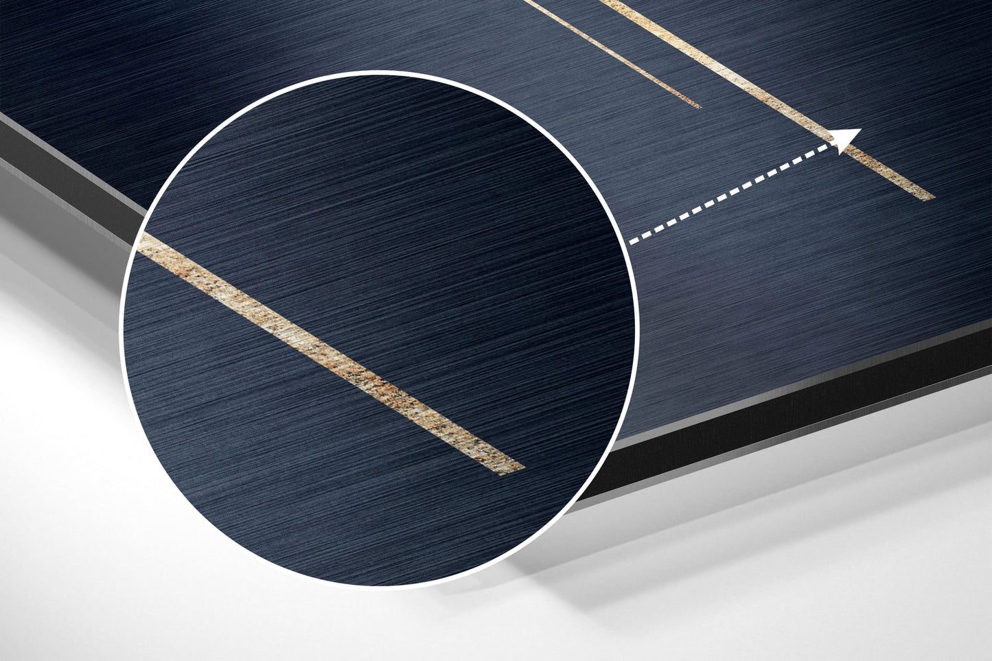 Close-up angled view of a white circular speech balloon wall art in brushed aluminum with gold diagonal lines against dark blue background.