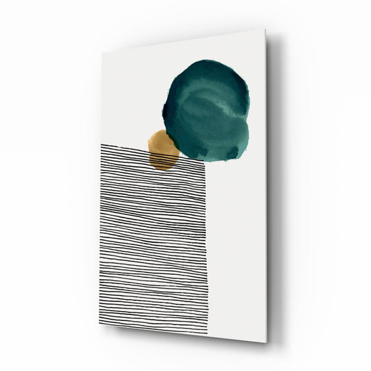 Glass wall art panel displayed at an angle showing a teal watercolor circle above a gold accent and black horizontal lines on white background.