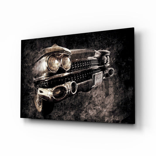 Angled front-view of a vintage car showing dual headlights and studded chrome grille against dark textured background on glass wall art.