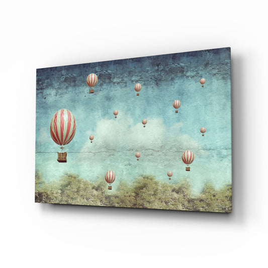 Angled three-quarter view of glass wall art featuring red and white striped hot air balloons floating over turquoise sky and textured landscape.