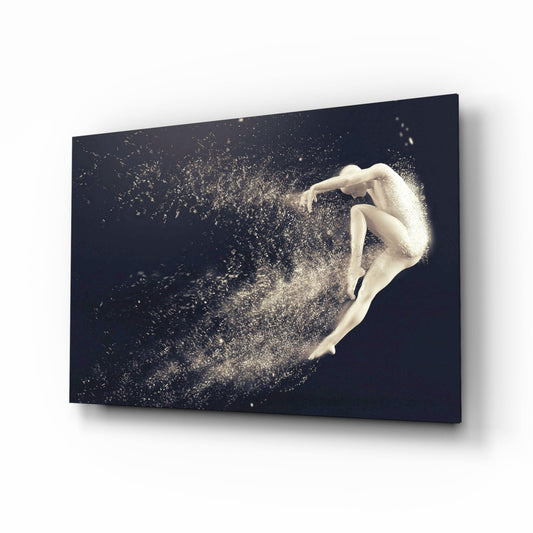 Glass wall art displaying a pale figure in a crouched leap pose dissolving into golden particles against a dark navy background, shown at an angled perspective.