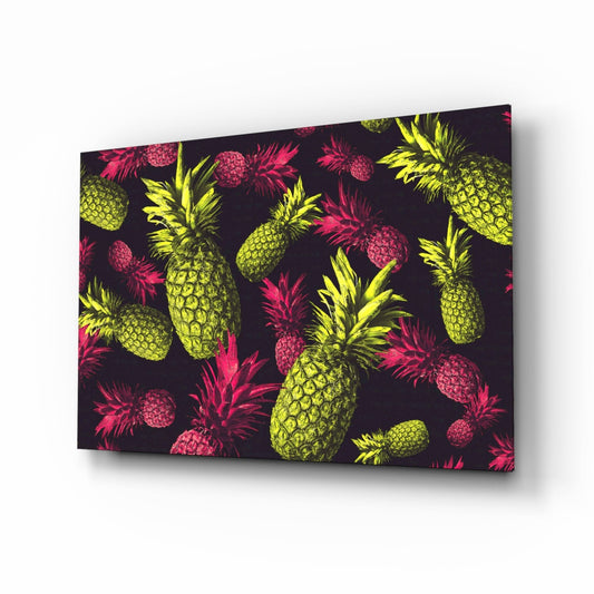 Angled perspective of tropical fruit glass wall art displaying yellow pineapples and pink raspberries on dark background.
