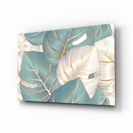 Angled perspective view of glass wall art displaying teal, cream, and gold tropical leaf pattern with detailed line work.
