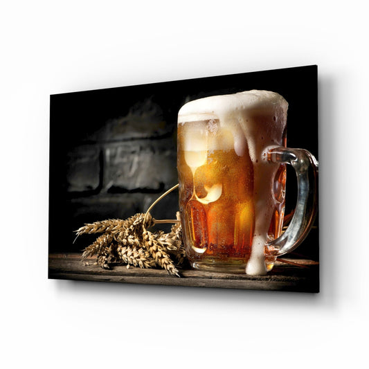 Angled view of framed canvas displaying a full beer mug with foam head and wheat stalks on dark wooden surface against black background.