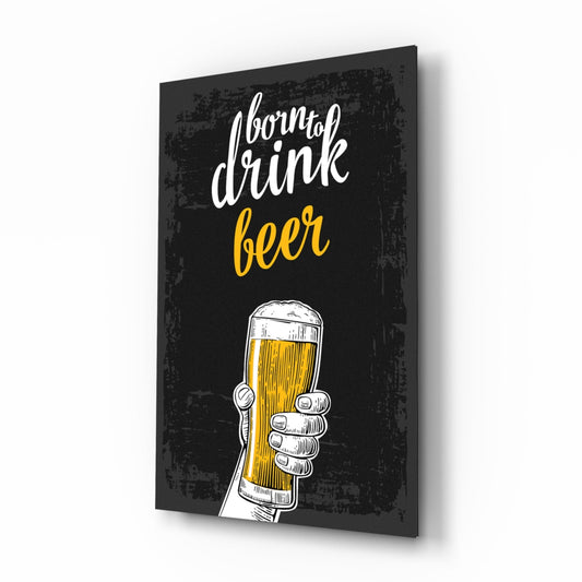 Black canvas wall art displaying white and yellow script text "born to drink beer" with illustrated hand holding a beer glass, shown at angled perspective.