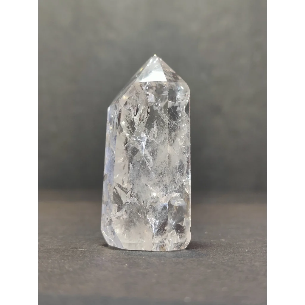 A clear faceted crackle quartz point tower with pointed top and natural internal inclusions in quartz crystal